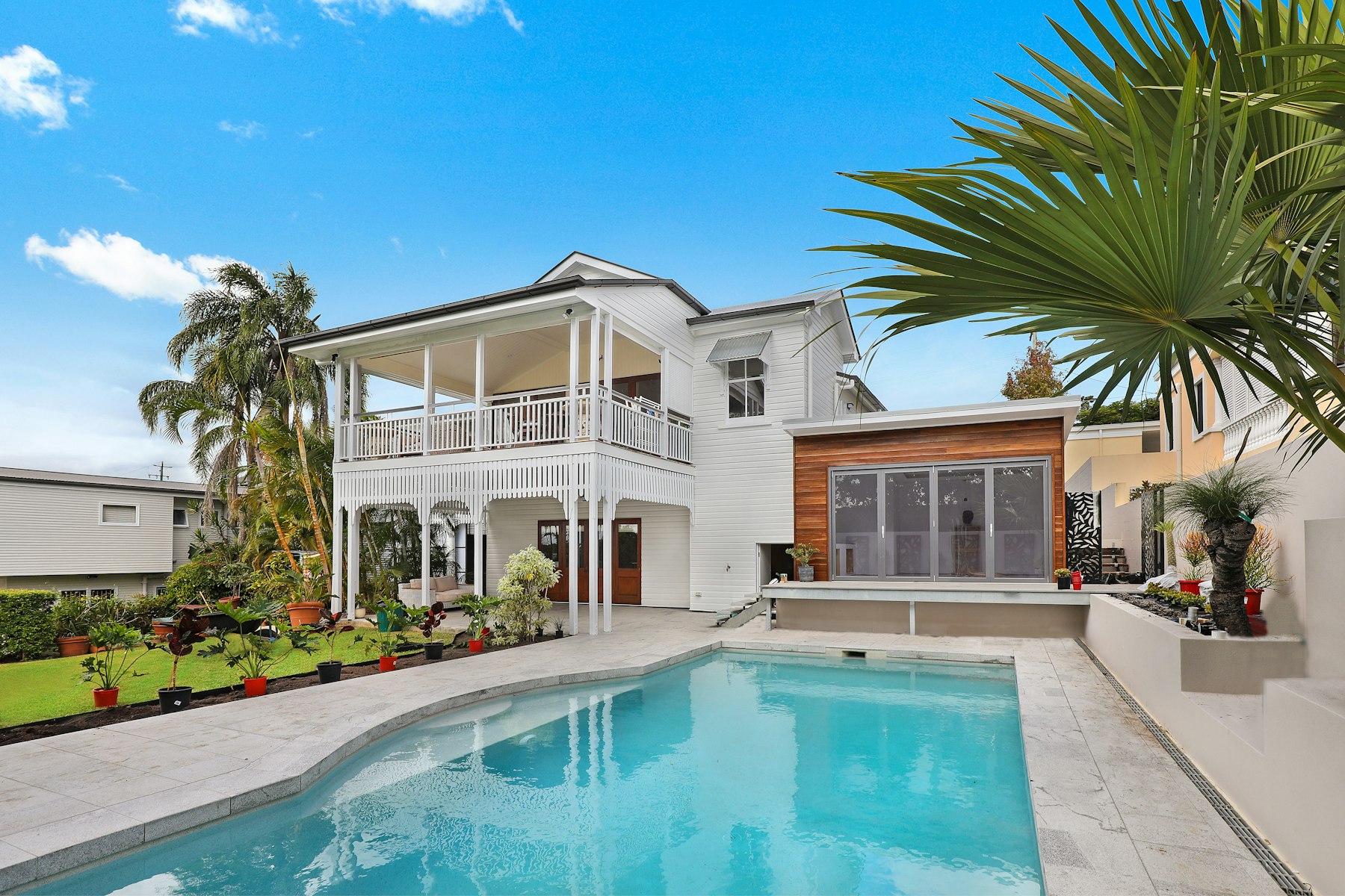 The house and its pool under the palms